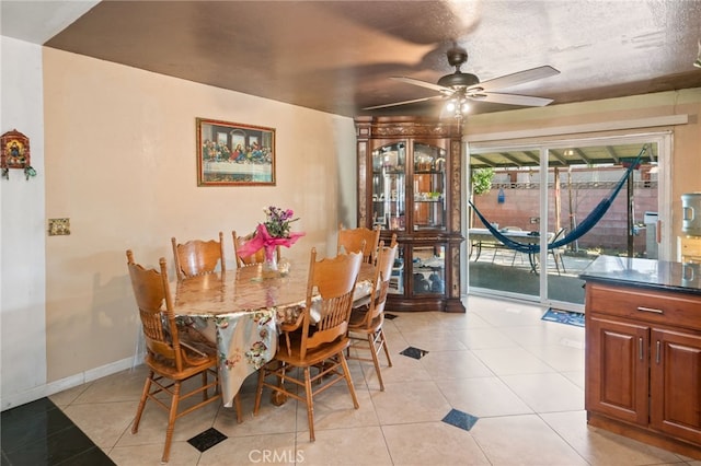 dining space with light tile patterned floors, baseboards, and a ceiling fan