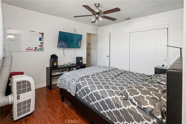 bedroom featuring wood finished floors, visible vents, ceiling fan, a closet, and a textured ceiling