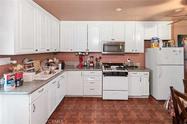 kitchen with light stone counters, white appliances, and white cabinetry