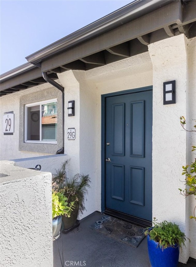 entrance to property featuring stucco siding