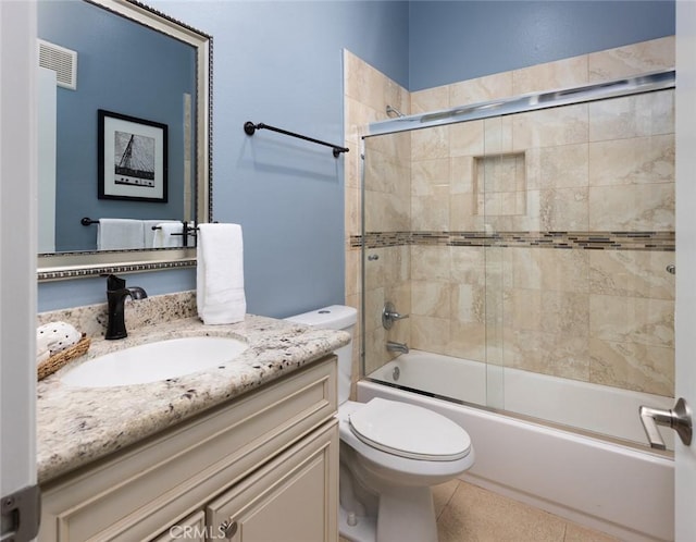 full bathroom featuring vanity, visible vents, bath / shower combo with glass door, tile patterned floors, and toilet