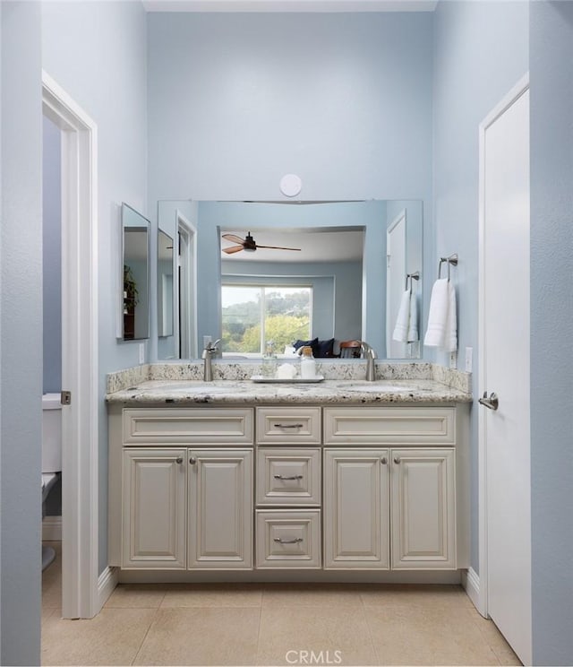 full bathroom with tile patterned flooring, double vanity, a ceiling fan, and a sink