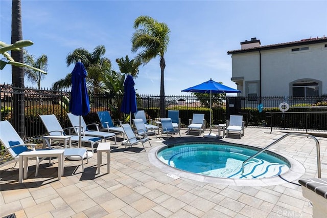 view of pool featuring a community hot tub, a patio area, and fence