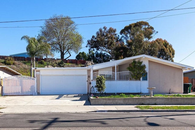 mid-century home featuring an attached garage, concrete driveway, fence, and a gate