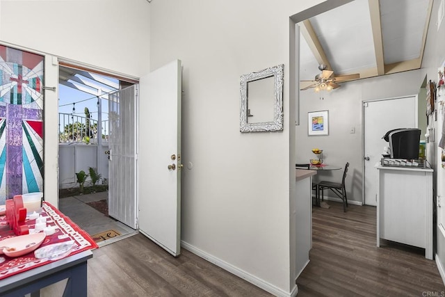 foyer entrance with dark wood-type flooring, a ceiling fan, baseboards, and beam ceiling