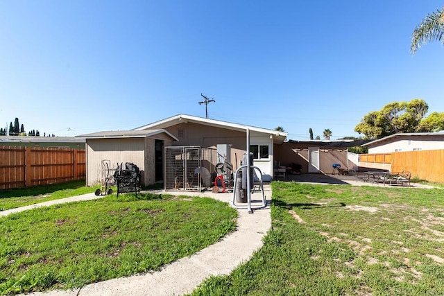 back of property featuring a patio area, a lawn, and a fenced backyard