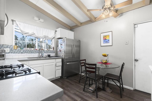 kitchen with dark wood-type flooring, decorative backsplash, freestanding refrigerator, white cabinetry, and a sink