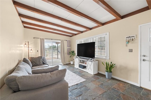 living room with beamed ceiling, baseboards, and stone tile flooring