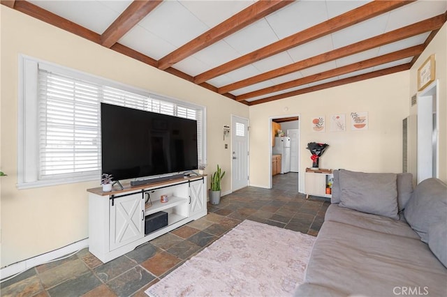 living room with beamed ceiling, baseboards, and stone tile floors