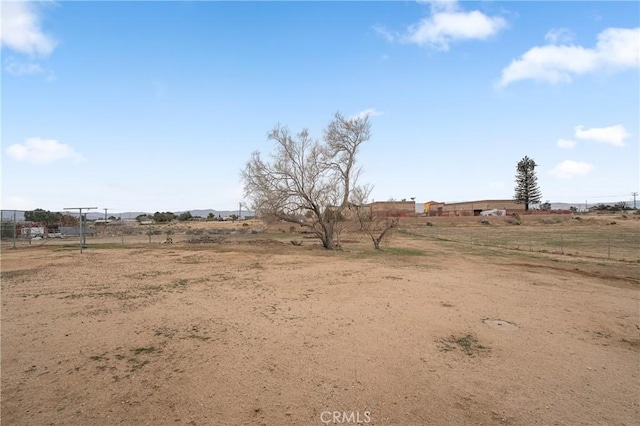 view of yard with a rural view and fence