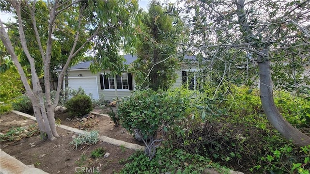 obstructed view of property with an attached garage