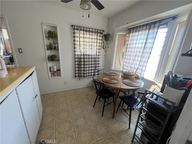 dining room with a ceiling fan, light floors, and a wealth of natural light