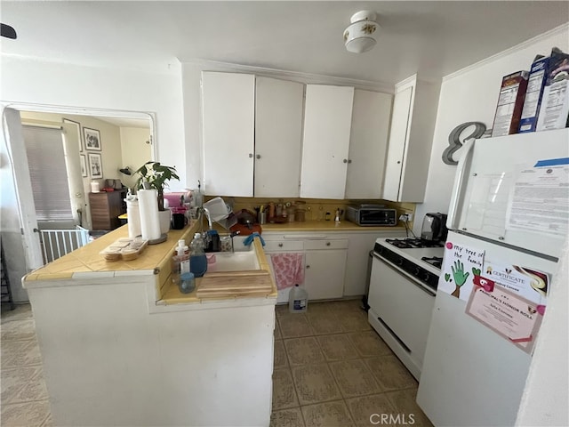 kitchen featuring white cabinetry, white appliances, and tile countertops