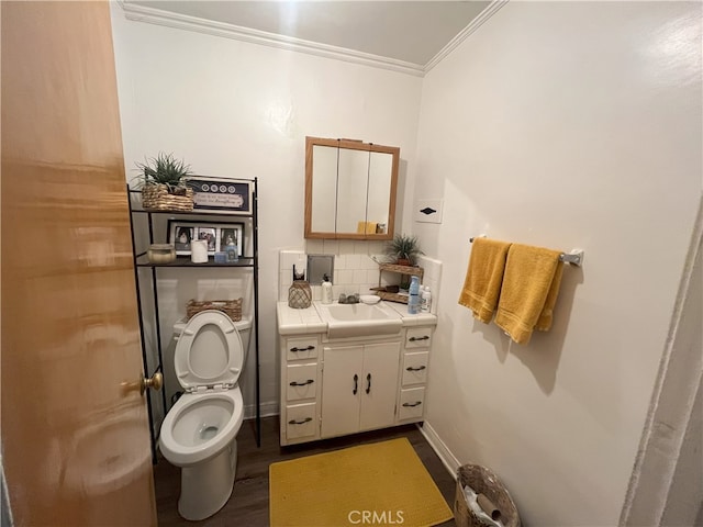 half bath featuring vanity, wood finished floors, ornamental molding, toilet, and tasteful backsplash