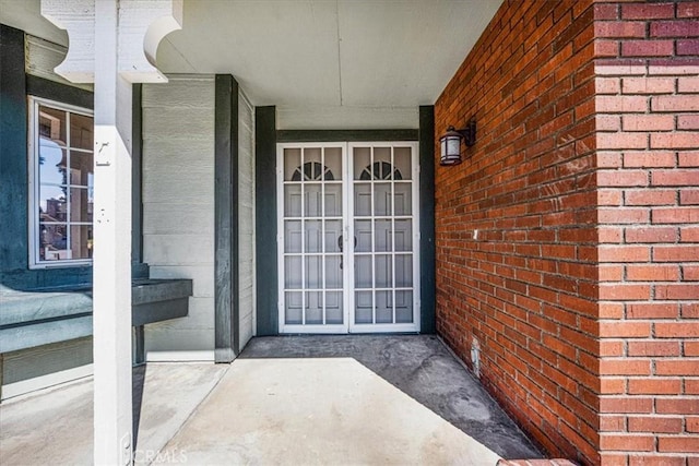 doorway to property featuring brick siding