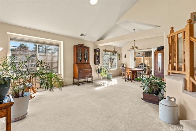 living area with vaulted ceiling, visible vents, and carpet floors