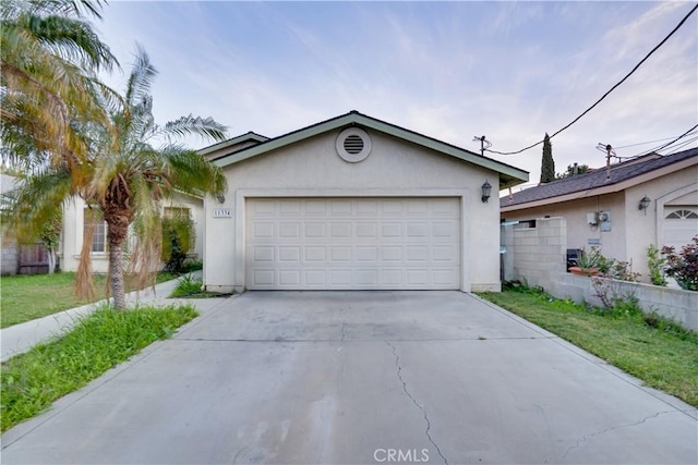 view of front of property with concrete driveway, a garage, and stucco siding