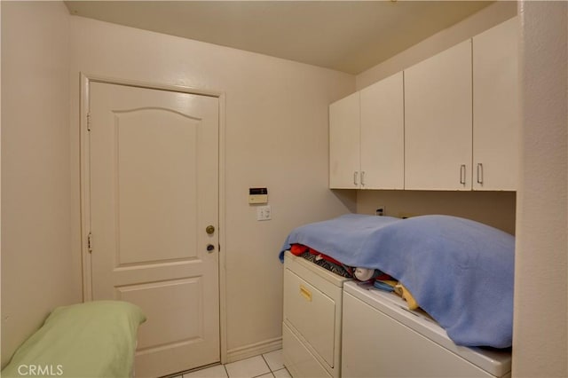 washroom featuring light tile patterned floors, cabinet space, and washing machine and dryer