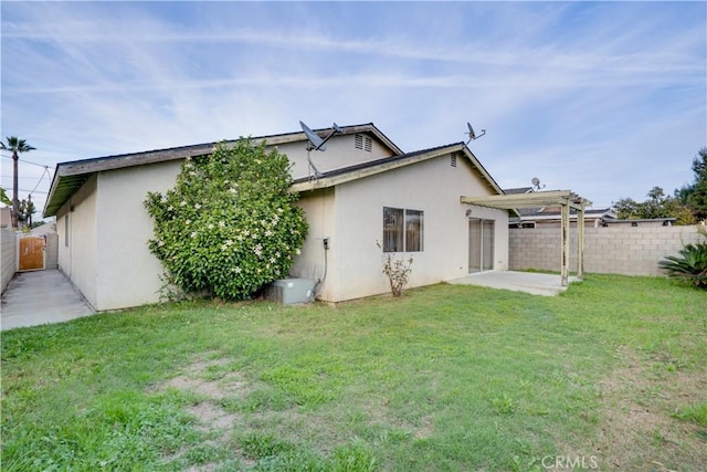 rear view of house featuring stucco siding, a patio, a lawn, and a fenced backyard