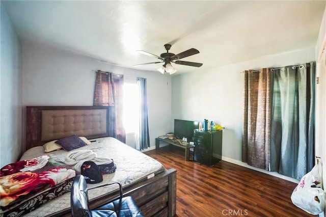 bedroom with a ceiling fan, wood finished floors, and baseboards