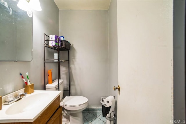 bathroom featuring tile patterned flooring, toilet, and vanity