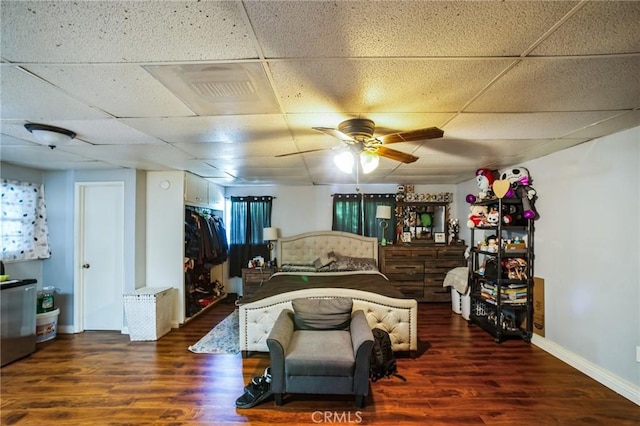 bedroom with a paneled ceiling, refrigerator, and wood finished floors
