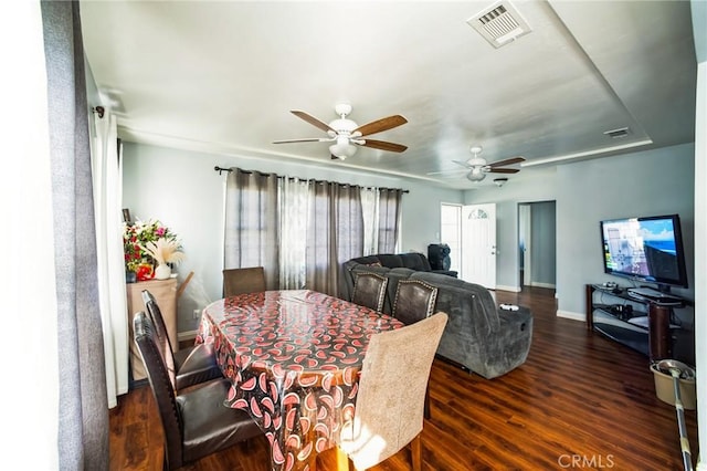 dining space with ceiling fan, visible vents, baseboards, and dark wood-style floors