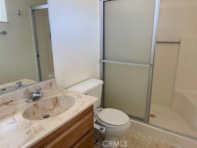 bathroom with a shower stall, toilet, and vanity