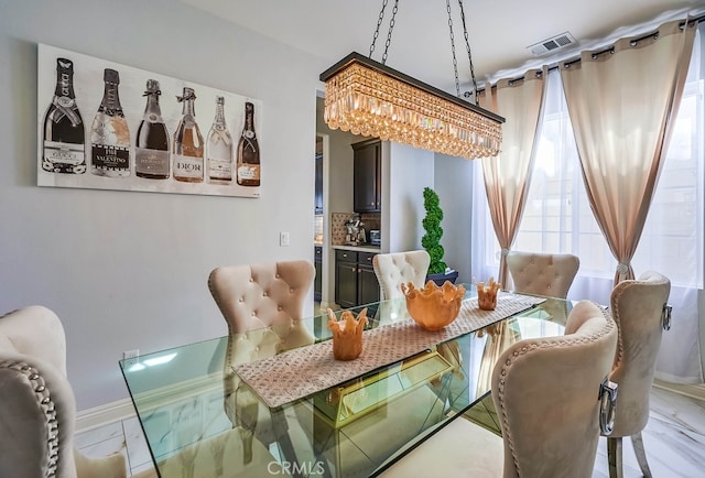 dining space with visible vents, marble finish floor, and a chandelier