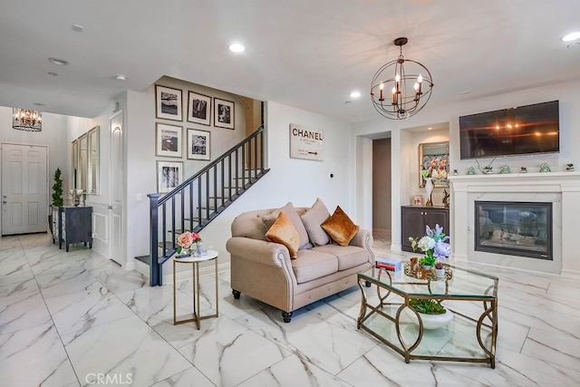 living area with marble finish floor, a glass covered fireplace, recessed lighting, stairway, and an inviting chandelier