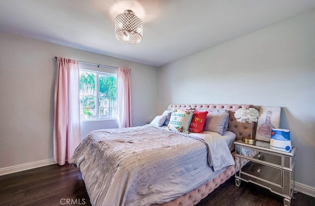 bedroom featuring baseboards and wood finished floors