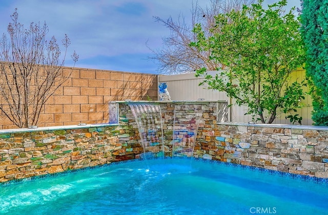 view of swimming pool featuring fence