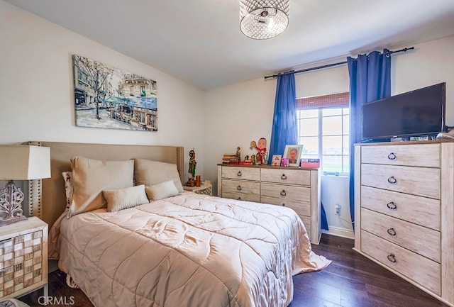 bedroom with baseboards and dark wood-style flooring