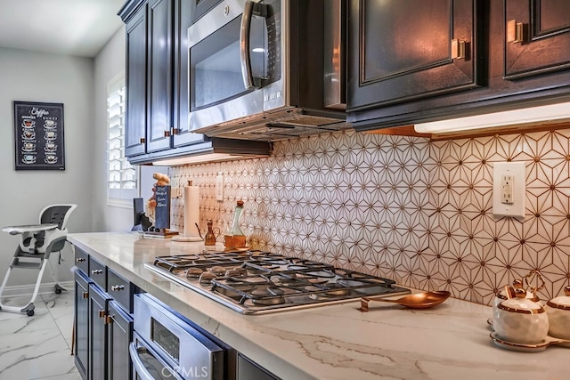 kitchen with backsplash, baseboards, light stone counters, appliances with stainless steel finishes, and marble finish floor