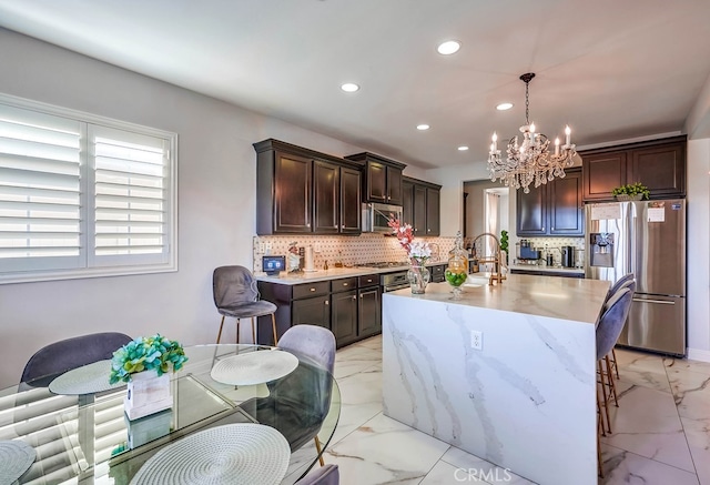 kitchen featuring dark brown cabinets, marble finish floor, backsplash, and stainless steel appliances