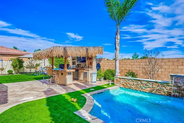 view of swimming pool with a patio, an outdoor kitchen, a fenced backyard, and outdoor dry bar