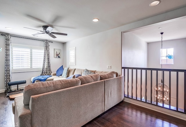 living area featuring recessed lighting, dark wood-style floors, and ceiling fan with notable chandelier