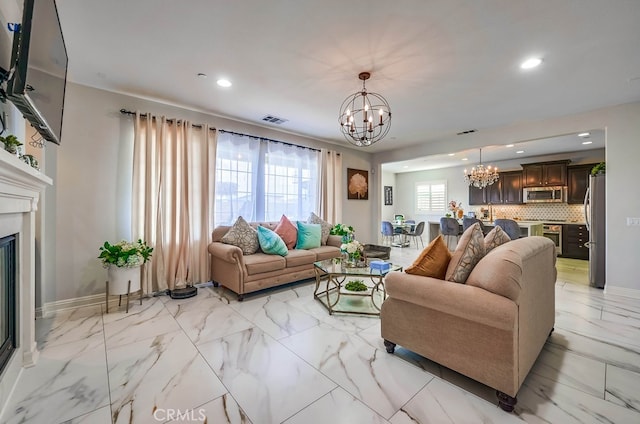 living room featuring visible vents, a glass covered fireplace, recessed lighting, baseboards, and a chandelier