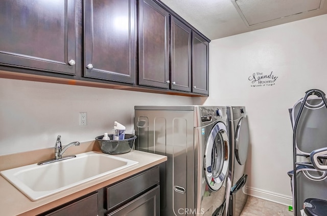 laundry area featuring a sink, baseboards, cabinet space, and washer and clothes dryer