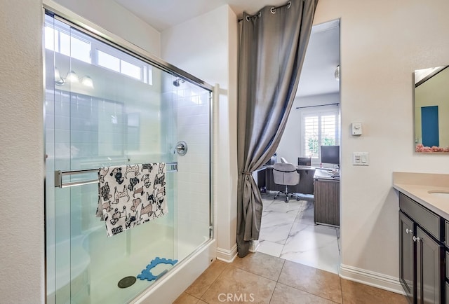 full bath with a shower stall, vanity, and baseboards