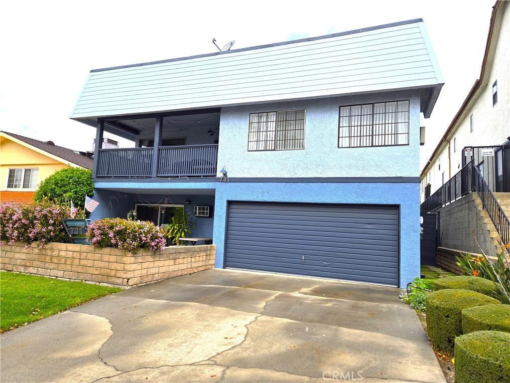 front of property with a balcony, stucco siding, concrete driveway, and a garage