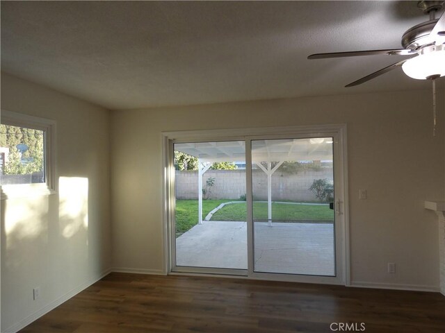 interior space featuring ceiling fan, baseboards, and wood finished floors