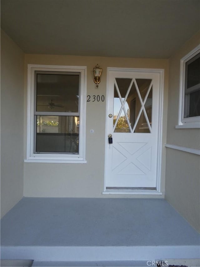 doorway to property featuring stucco siding