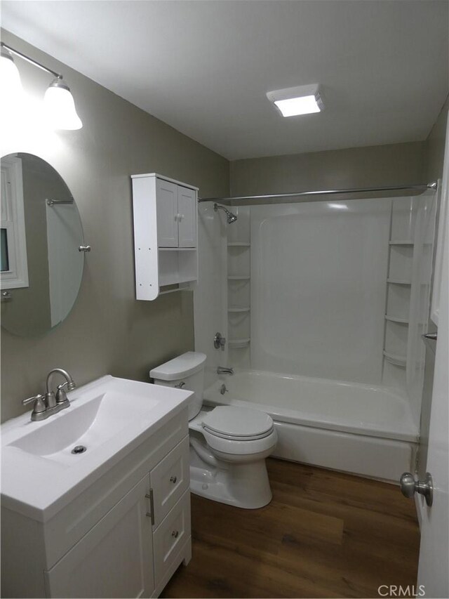 bathroom featuring shower / bathtub combination with curtain, toilet, vanity, and wood finished floors