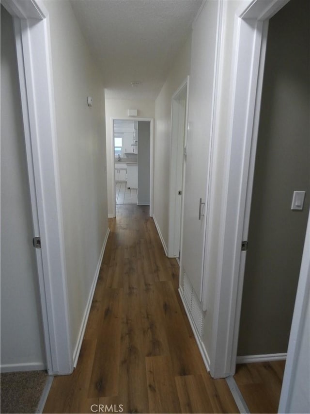 hall featuring baseboards and wood finished floors