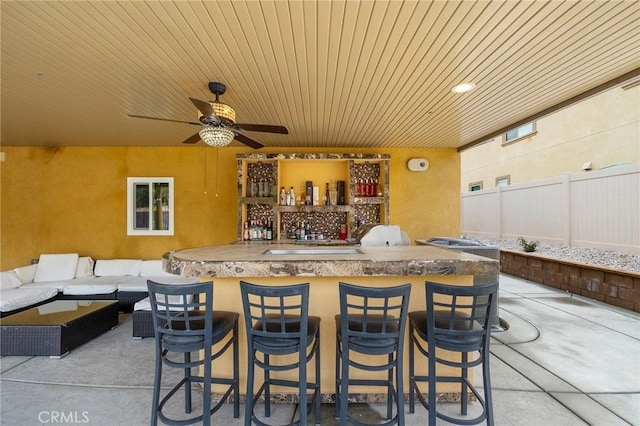 view of patio / terrace with fence, an outdoor kitchen, outdoor wet bar, an outdoor living space, and ceiling fan