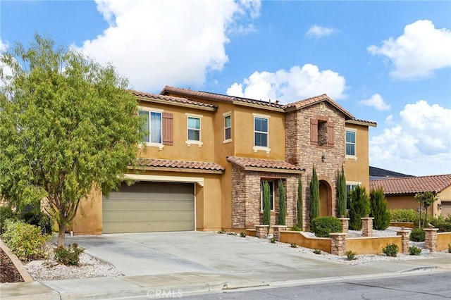 mediterranean / spanish home with stone siding, stucco siding, driveway, and a garage