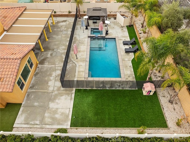 view of pool with a pool with connected hot tub, fence, a gazebo, a yard, and a patio area