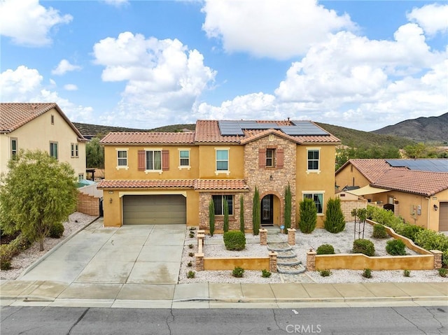 mediterranean / spanish-style home with stucco siding, stone siding, an attached garage, and a tile roof