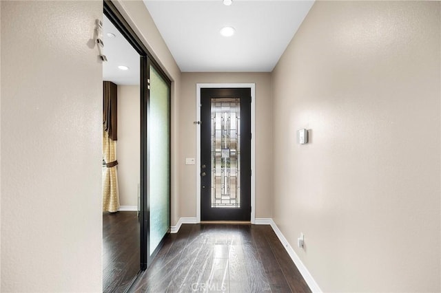 entryway with dark wood-type flooring and baseboards